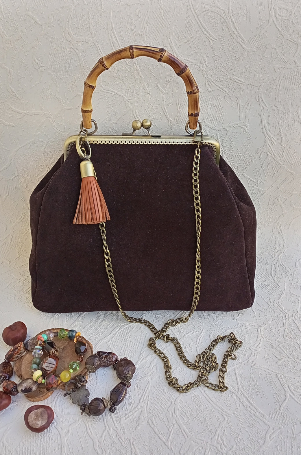 Close-up of brass kisslock clasp on brown suede leather bag