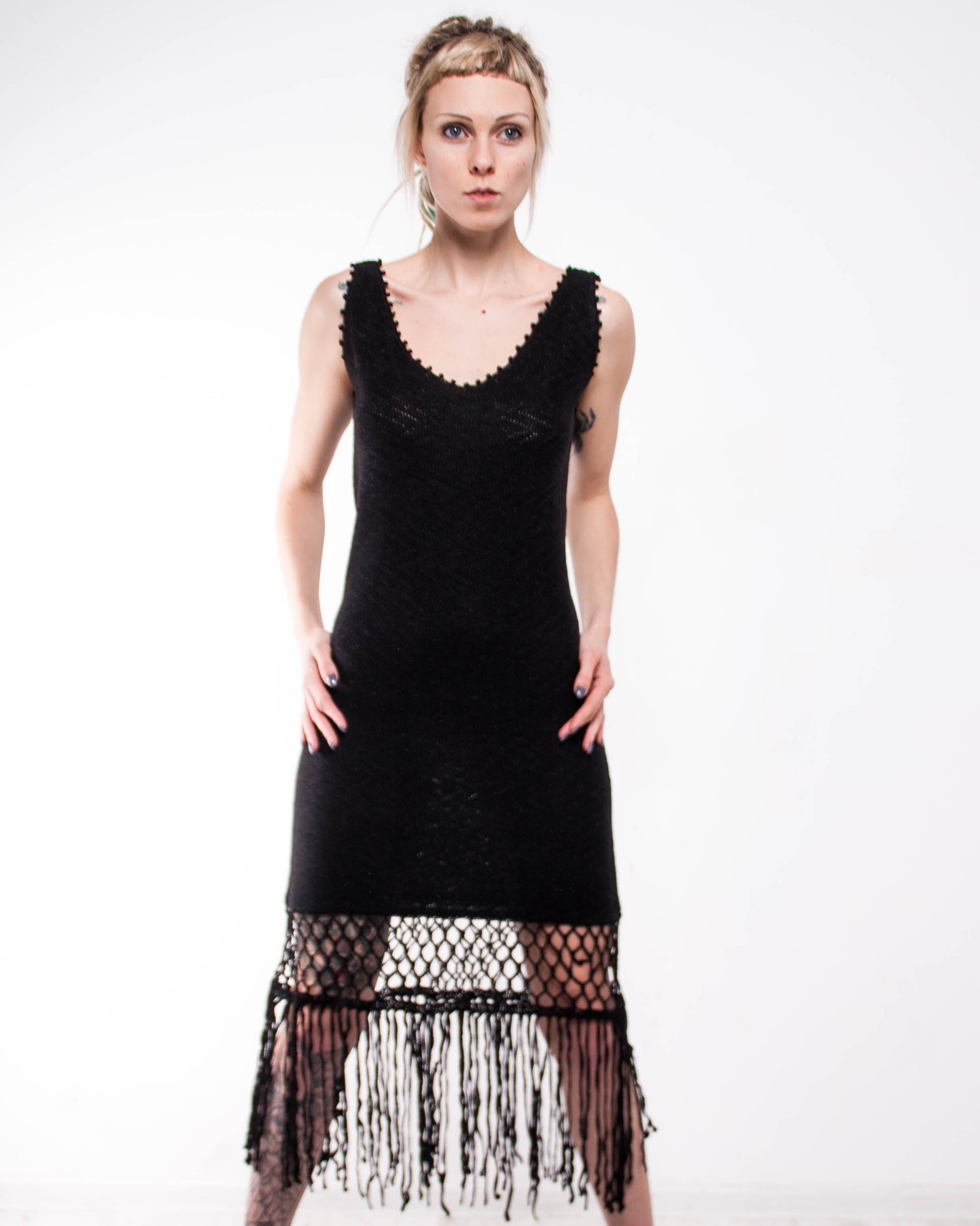 Woman wearing a mini black dress with fringe details 