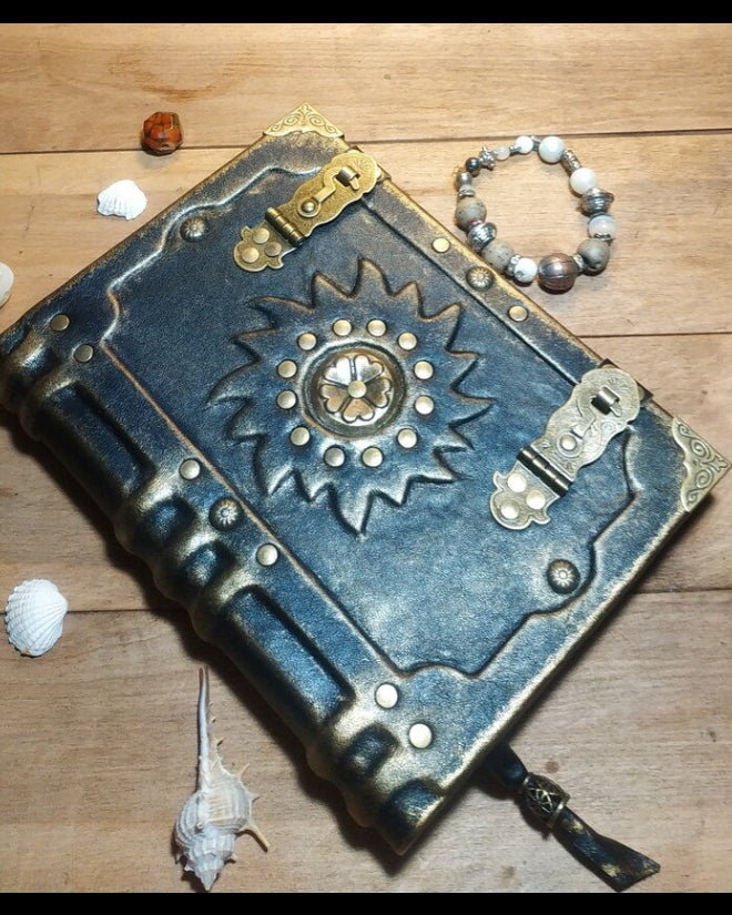 Decorative leather-bound book with metallic embellishments on a wooden surface.