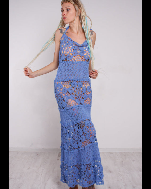 Woman wearing a blue crochet lace maxi sundress against a white background