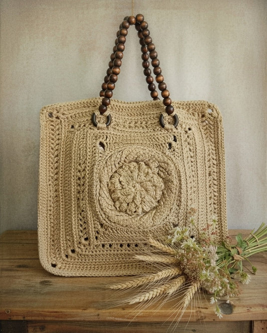 Crocheted bag with wooden handles on a wooden surface