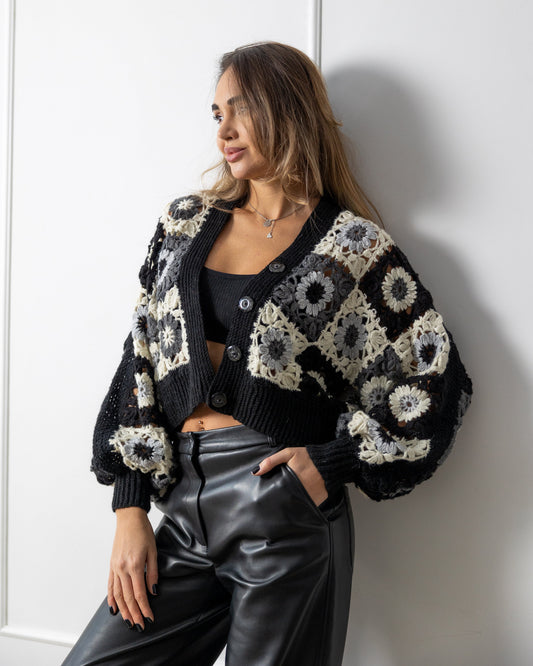 Woman wearing a black and white crochet granny square patterned cardigan 