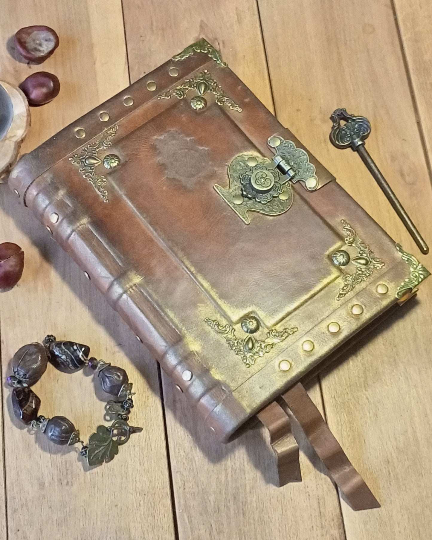 Decorative aged rusty brown leather-bound book with brass accents on a wooden surface