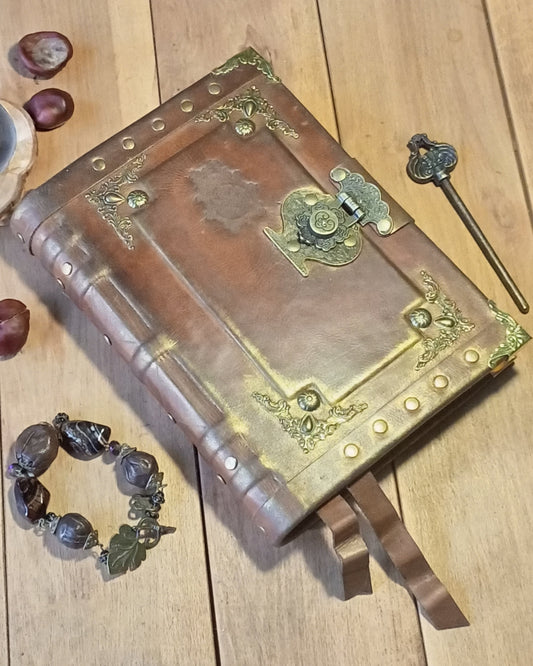 Decorative aged rusty brown leather-bound book with brass accents on a wooden surface