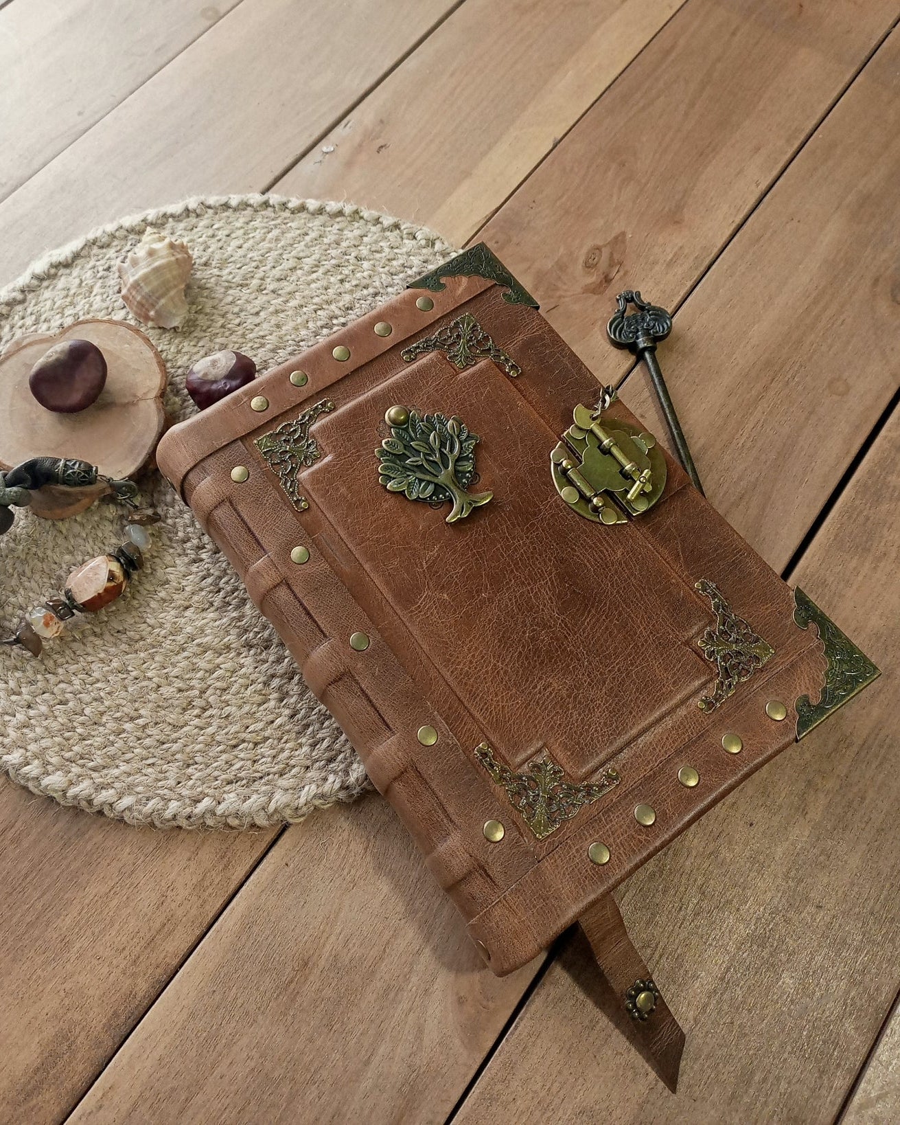 Decorative leather-bound book with metal brass embellishments on a wooden surface