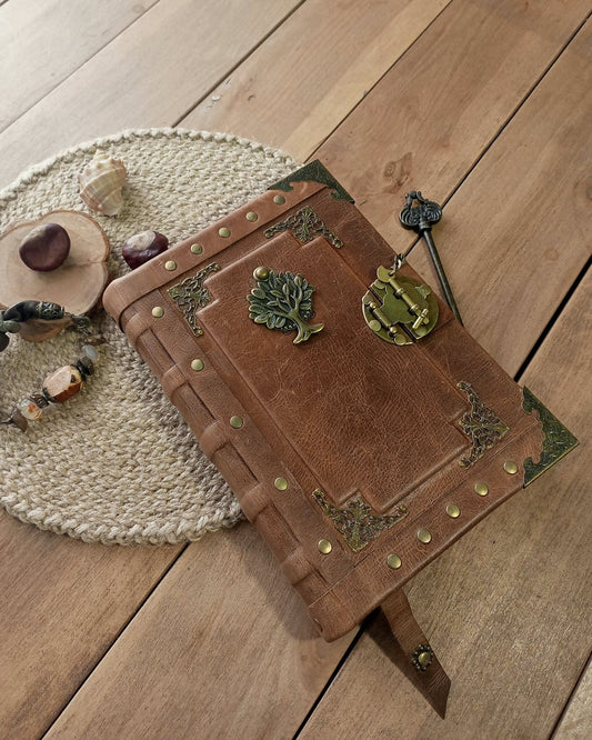 Decorative leather-bound book with metal brass embellishments on a wooden surface