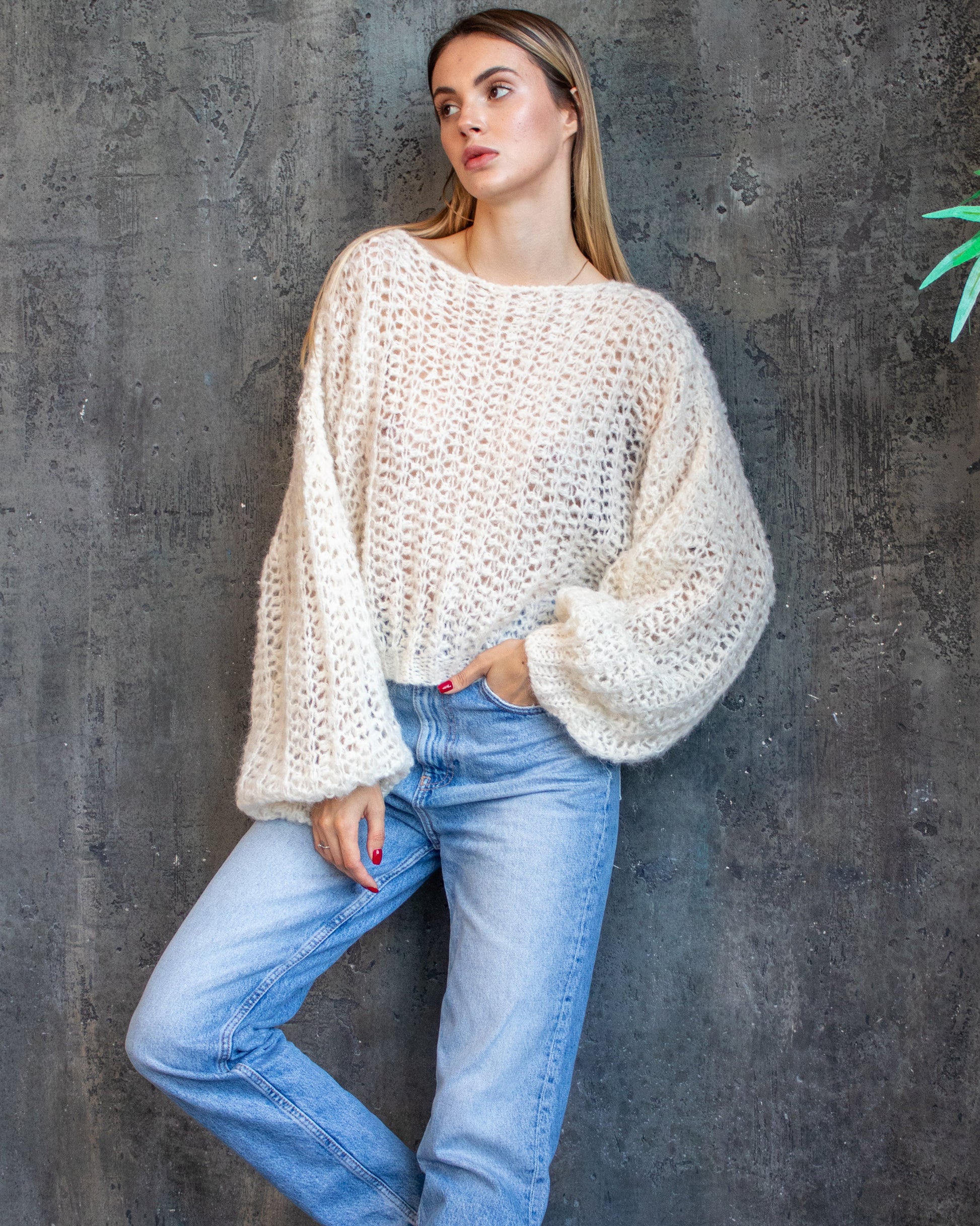 Woman wearing a white lacy crochet  sweater 